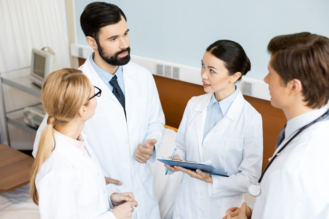 side-view-of-doctors-team-discussing-diagnosis-in-5QB7U4B-1.jpg